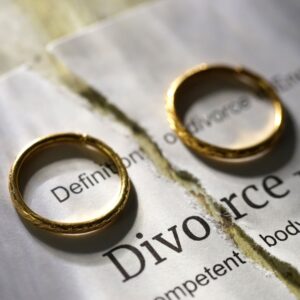 Divorce decree split in half with a ring on either side of the paper.