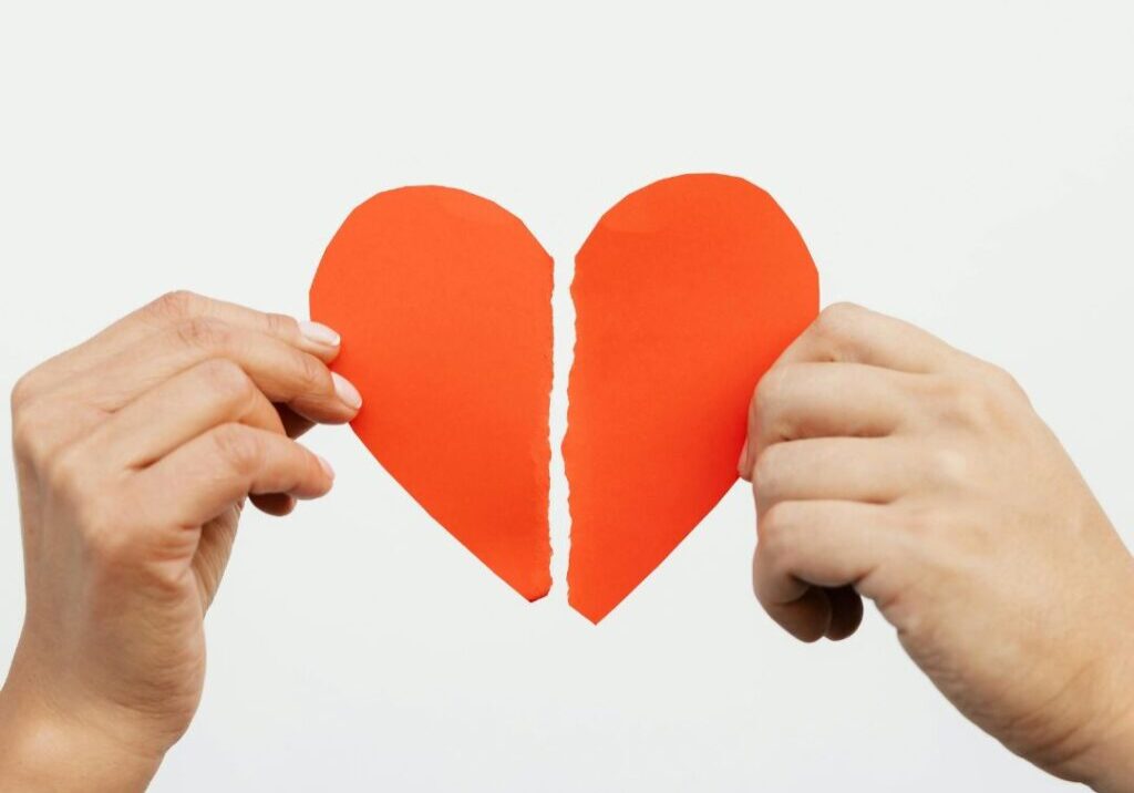 broken heart with two hands holding each half